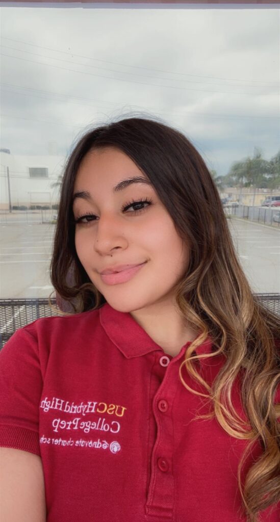 Photo of Kymberly wearing the red Hybrid High polo shirt